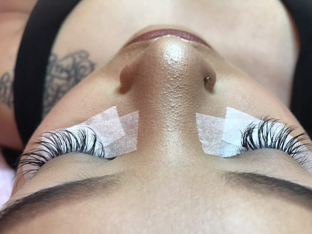 Freshly applied lash extensions, seen from above with under-eye pads still in place